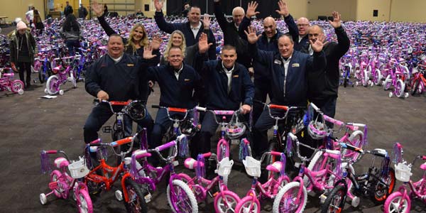 Les Schwab employees in a room full of children’s bikes that they helped assemble.