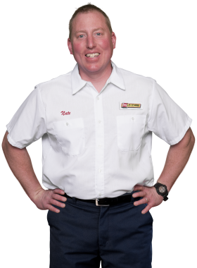 A Les Schwab technician stands arms akimbo. His name is Nate