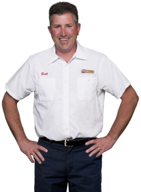 A Les Schwab technician stands arms akimbo. His name is Brett