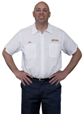 A Les Schwab technician stands arms akimbo. His name is John