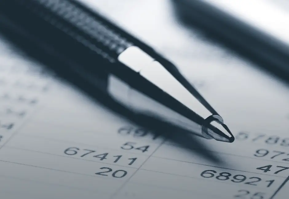 Pen and calculator over ledger book