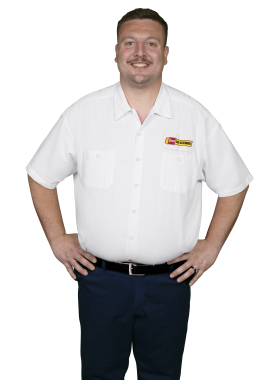 A Les Schwab technician stands arms akimbo. His name is Brian