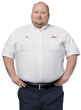 A Les Schwab technician stands arms akimbo. His name is Don