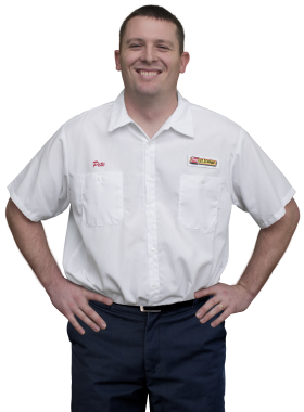 A Les Schwab technician stands arms akimbo. His name is Pete