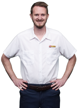 A Les Schwab technician stands arms akimbo. His name is Austin