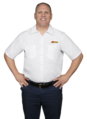 A Les Schwab technician stands arms akimbo. His name is Dustin