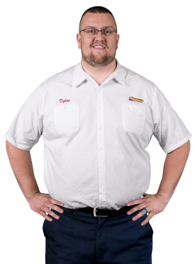 A Les Schwab technician stands arms akimbo. His name is Dylan