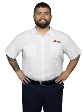 A Les Schwab technician stands arms akimbo. His name is Randall