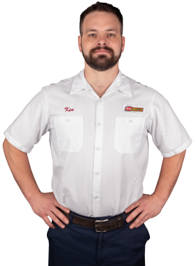 A Les Schwab technician stands arms akimbo. His name is Kenneth