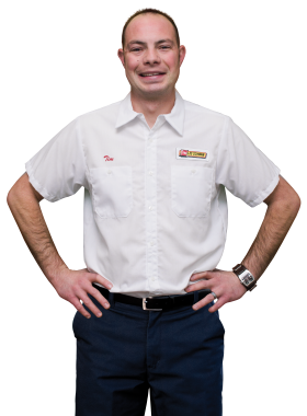 A Les Schwab technician stands arms akimbo. His name is Timothy