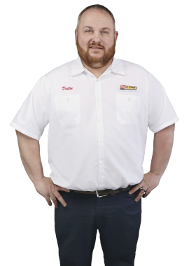 A Les Schwab technician stands arms akimbo. His name is Dustin