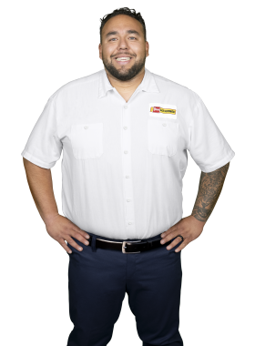 A Les Schwab technician stands arms akimbo. His name is Jose